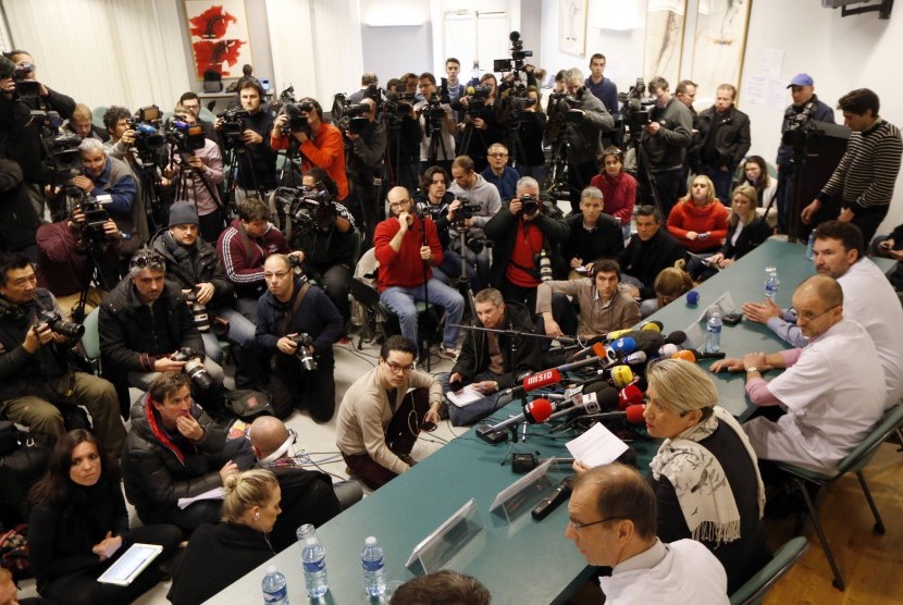 Journalists surround a table where medical team (on the right side) attend a news conference at the CHU hospital emergency unit in Grenoble, French Alps, where retired seven-times Formula One world champion Michael Schumacher is hospitalized after a ski ac