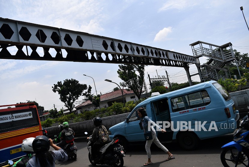 JPO Pasar Minggu. Warga dan pengendara motor melintas di dekat Jembatan Penyeberangan Orang (JPO) yang rusak di Pasar Minggu, Jakarta Selatan, Senin (4/3/2019). 