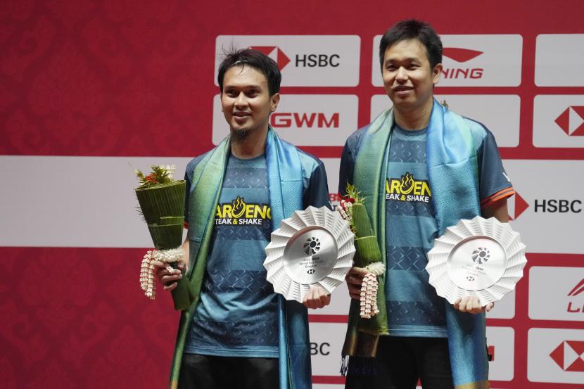 Juara dua Indonesia Mohammad Ahsan, kiri, dan Hendra Setiawan memegang trofi mereka saat upacara kemenangan ganda putra pada kompetisi bulutangkis BWF World Tour Finals di Bangkok, Thailand, Ahad, 11 Desember 2022. 