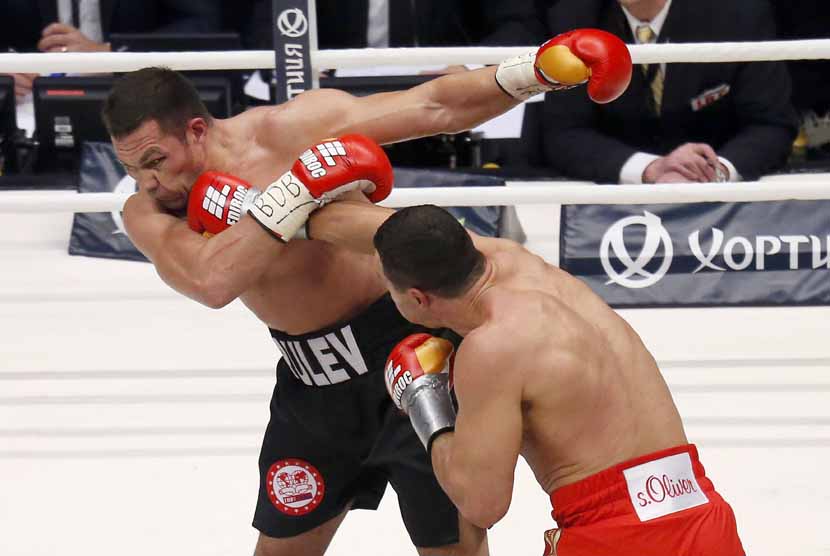 Juara dunia kelas berat WBA, WBO, IBO dan IBF asal Ukraina, Vladimir Klitschko (kanan), melepaskan pukulan yang mengenai wajah penantangnya asal Bulgaria, Kubrat Pulev, dalam pertarungan di Hamburg, Jerman, Sabtu (15/11). 