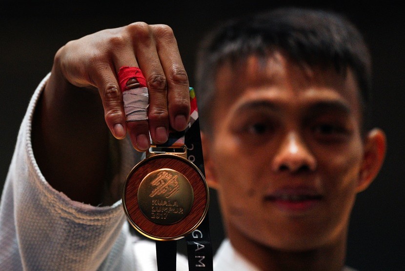 Judoka Indonesia asal Jawa Barat Iksan Apriyadi menunjukkan medali emas usai menjuarai final judo -73 Kg putra SEA Games XXIX Kuala Lumpur di KLCC, Kuala Lumpur, Malaysia, Sabtu (26/8). 