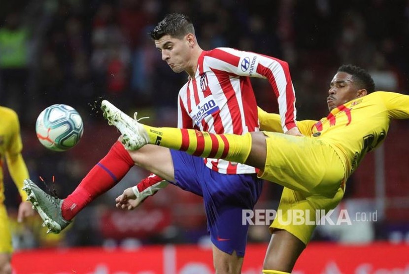 Junior Firpo (kanan) dan Alvaro Morata (kiri) berebut bola pada pertandinigan La Liga Spanyol antara Atletico Madrid melawan FC Barcelona di Wanda Metropolitano stadium, Madrid, Senin (2/12) dini hari.