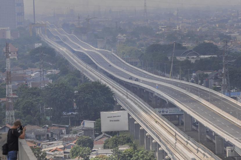 Jurnalis foto mengambil gambar suasana tol layang Jakarta-Cikampek (elevated) di Bekasi, Jawa Barat