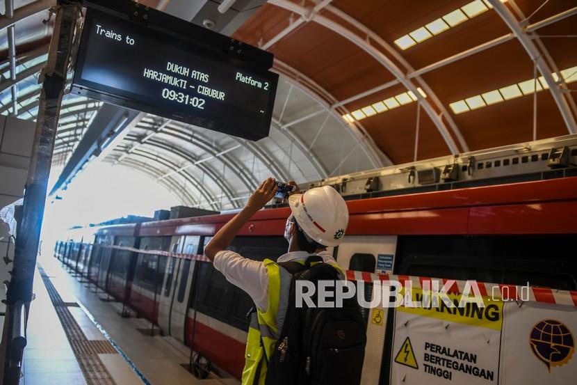 Jurnalis memotret proyek infrastruktur stasiun LRT (Light Rail Transit) Jabodebek di Pancoran, Jakarta, Kamis (10/3/2022). PT Kereta Api Indonesia (Persero) atau KAI menandatangani Nota Kesepahaman (MoU) dengan PT Jakarta Propertindo (Perseroda) tentang rencana kerja sama atas pengelolaan dan pengembangan kawasan berorientasi transit stasiun LRT Jabodebek yang berlokasi di Provinsi DKI Jakarta.