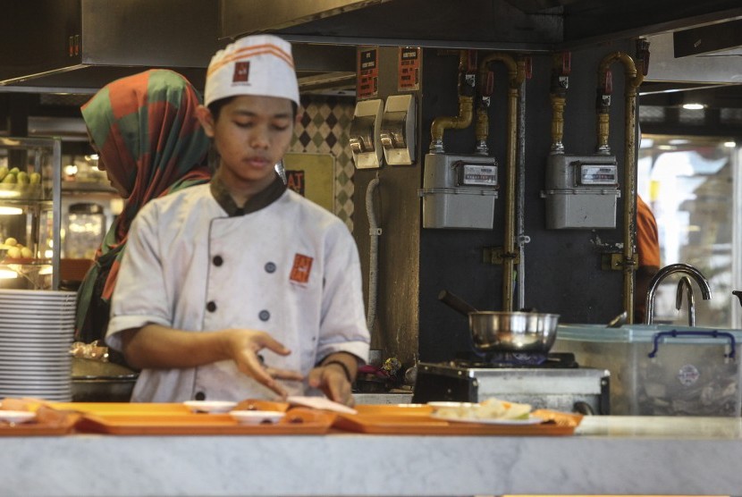 Juru masak memasak makanan untuk konsumen menggunakan gas yang disalurkan PGN di pusat perbelanjaan FX Sudirman, Jakarta, Selasa (23/8). 