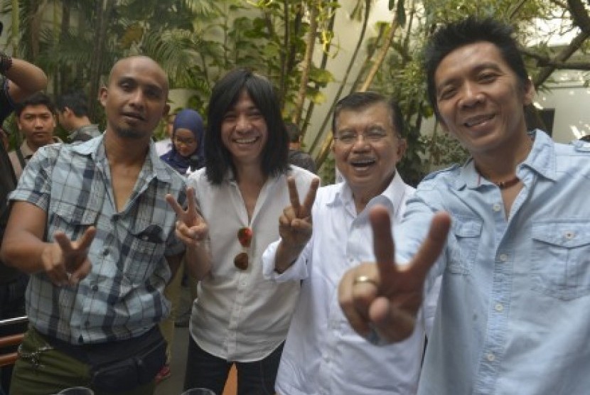 Jusuf Kalla (kedua kanan) bersama personel Band Slank Bimbim (kanan), Abdee (kedua kiri) dan Ivan (kiri) mengacungkan jari mereka membentuk V yang berarti dua, kemenangan dan perdamaian ketika bertemu di Jakarta, Senin (2/6).