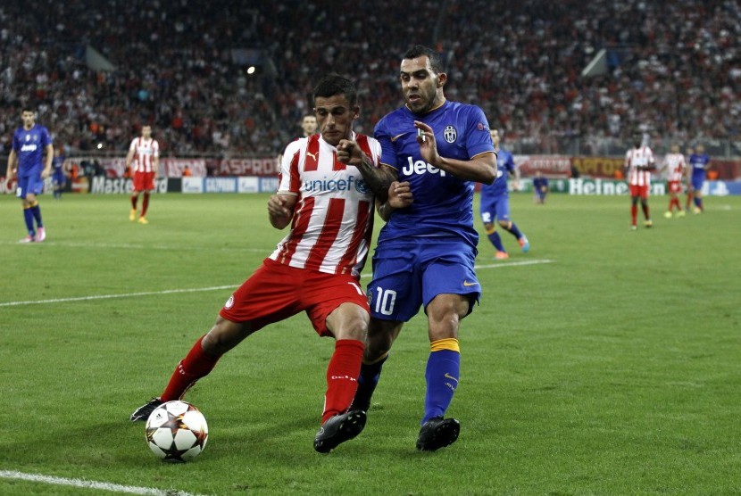 Juventus' Carlos Tevez (R) challenges Olympiakos' Omar Elabdellaoui during their Champions League soccer match at Karaiskaki stadium in Piraeus, near Athens, October 22, 2014.