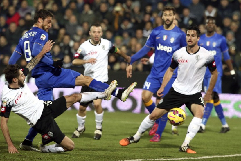 Juventus' Claudio Marchisio (top, L) scores against Cesena during their Italian Serie A soccer match in Cesena, February 15, 2015. 