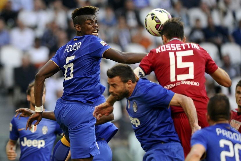 Juventus' Pogba jumps for the ball against Cagliari's Rossettini during their Serie A soccer match at the Juventus stadium in Turin