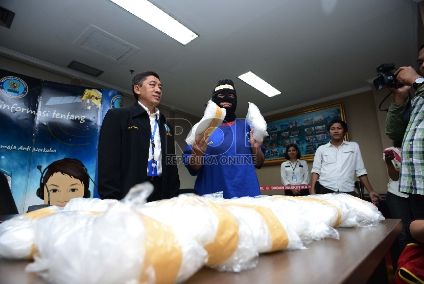  Kabag Humas BNN, Slamet Pribadi (kiri) bersama tersangka berinisial F (kanan) menunjukan barang bukti narkotika jenis sabu saat rilis narkotika di kantor BNN, Jakarta Timur, Senin (23/2).  (Republika/Raisan Al Farisi)