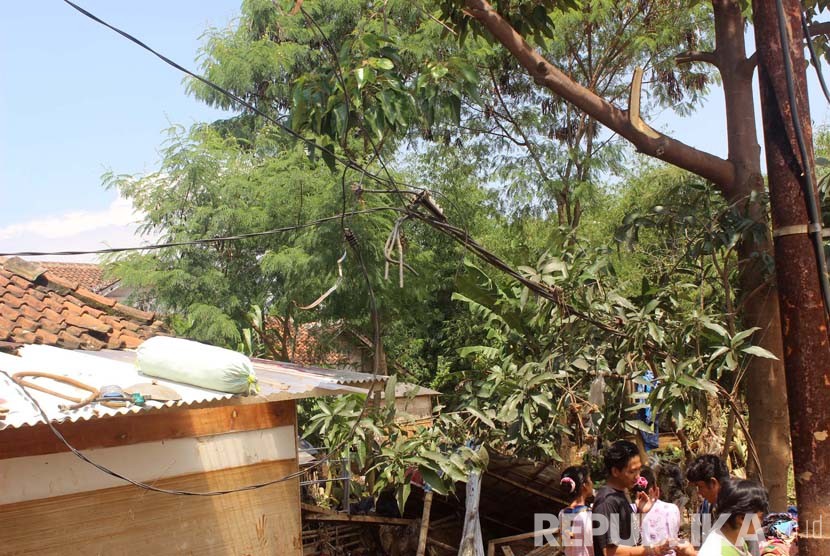 Kabel listrik tertarik oleh rumah yang tersered banjir dikhawatirkan masih teraliri listrik di Kampung Pamoyanan, Desa Panenjoan, Kecamatan Cicalengka, Kabupaten Bandung, Rabu (13/4). (foto: Dede Lukman)