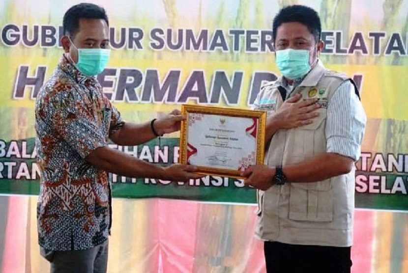 Kabid Penyelenggaraan Penyuluhan Pertanian - Pusluhtan, Joko Samiyono (kiri) menyerahkan sertifikat Pin Emas kepada Gubernur Sumsel H Herman Deru