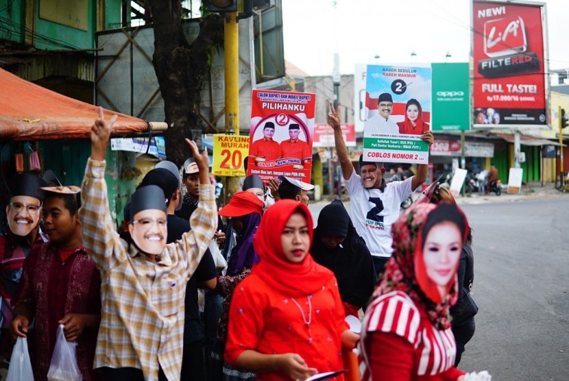 Kader PDIP berkampanye dengan menggunakan topeng bergambar Gus Ipul dan Puti Guntur.