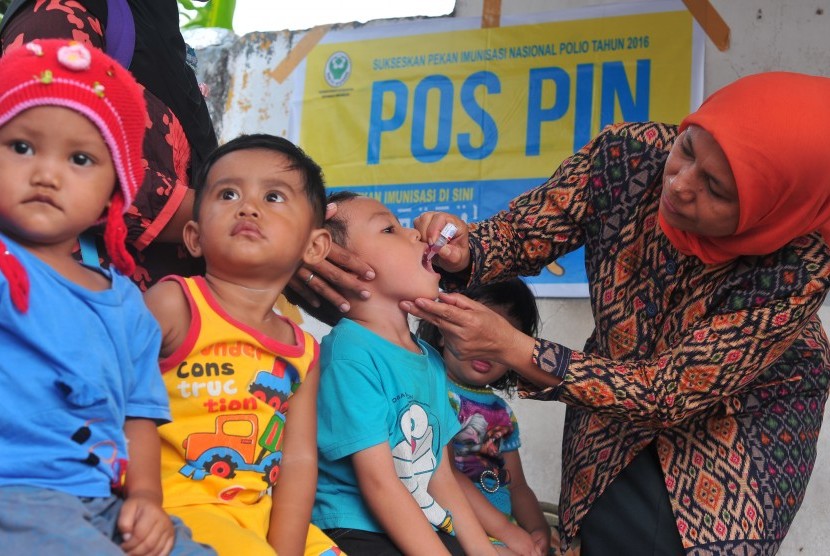 Kader Posyandu memberikan vaksin polio tetes pada salah satu anak peserta Pekan Imunisasi Nasional (PIN).