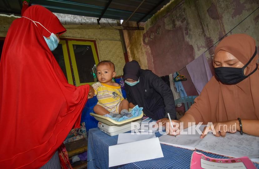 Fatayat NU Jatim Siapkan Kader Daerah Cegah Stunting. Kader Posyandu menimbang berat badan balita.