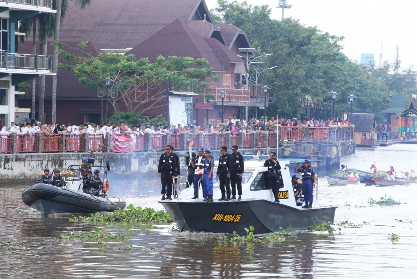 Kadispora Kalsel Zakly Asswan mengusung obor Asian Games 2018 di atas perahu motor Polairud Polda Kalsel dan TNI AL melintasi Sungai Martapura di Banjarmasin, Kalimantan Selatan, Senin (30/7)
