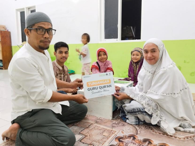 Kadiv Program dan Pendayagunaan BMH Perwakilan Sumut, Lukman menyerahkan tunjangan dari BMH kepada Ibu Maya, guru Quran yang berkiprah di Gang Bengkok, Medan.