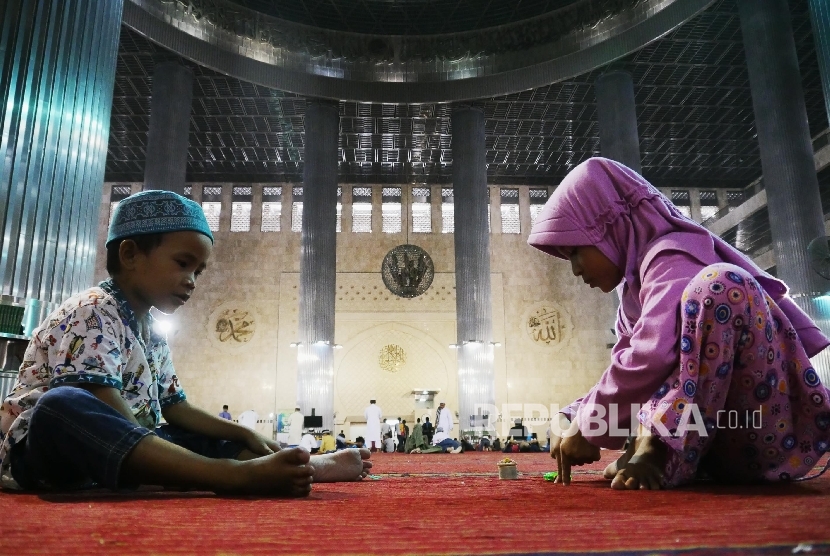 Kakak beradik Salu (kanan) dan Salik bermain di Masjid Istiqlal Jakarta, Ahad (12/6).  (Republika/Darmawan)