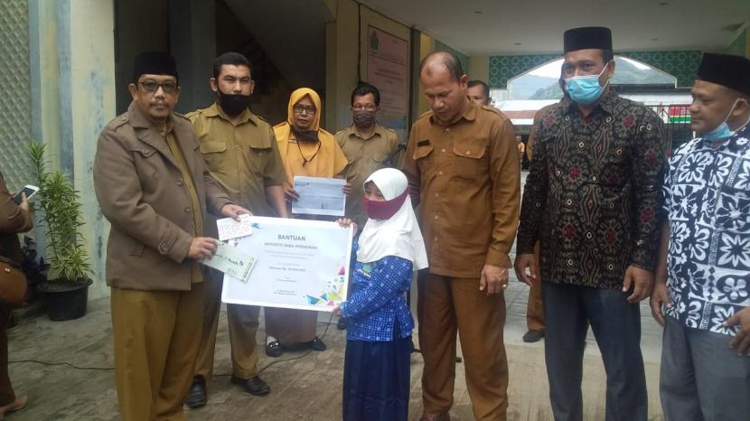 Kakankemenag Aceh Besar menyerahkan bantuan  untuk siswa korban kebakaran berupa deposito pendidikan Rp 30 juta.