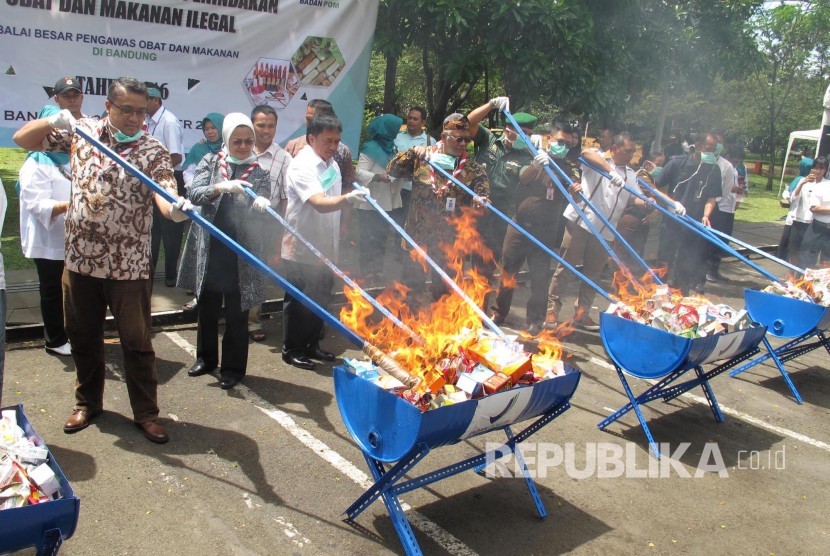 Kakuarda Jabar Dede Yusuf (kanan) dan Kepala Badan Pengawas Obat dan Makanan (BPOM) RI Penny Kusumastuti Lukito (kedua kanan) membakar obat-obatan dan kosmetik ilegal pada pemusnahan Hasil Pengawasan dan Penindakan Obat dan makanan Ilegal oleh BPOM, di hal