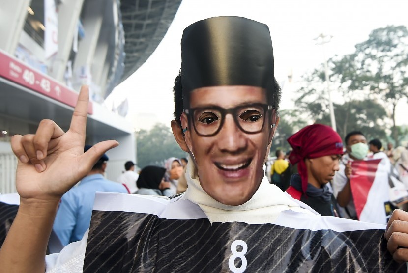 Kampanye Akbar. Pendukung capres dan cawapres nomor urut 02 Prabowo dan Sandiaga Uno mengenakan topeng Sandiaga Uno saat kampanye akbar di Stadion Gelora Bung Karno, Senayan, Jakarta, Ahad (7/4). 
