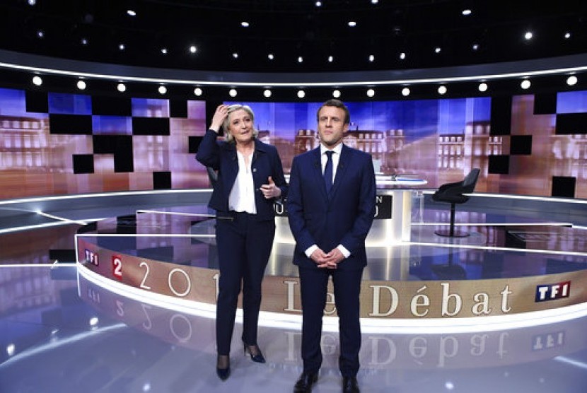 Kandidat presiden Prancis dari Partai National Front Marine Le Pen (kiri) dan Emmanuel Macron dari gerakan En Marche! Emmanuel Macron berpose sebelum memulai debat televisi terakhir di La Plaine-Saint-Denis, utara Paris, Rabu, 3 Mei 2017.