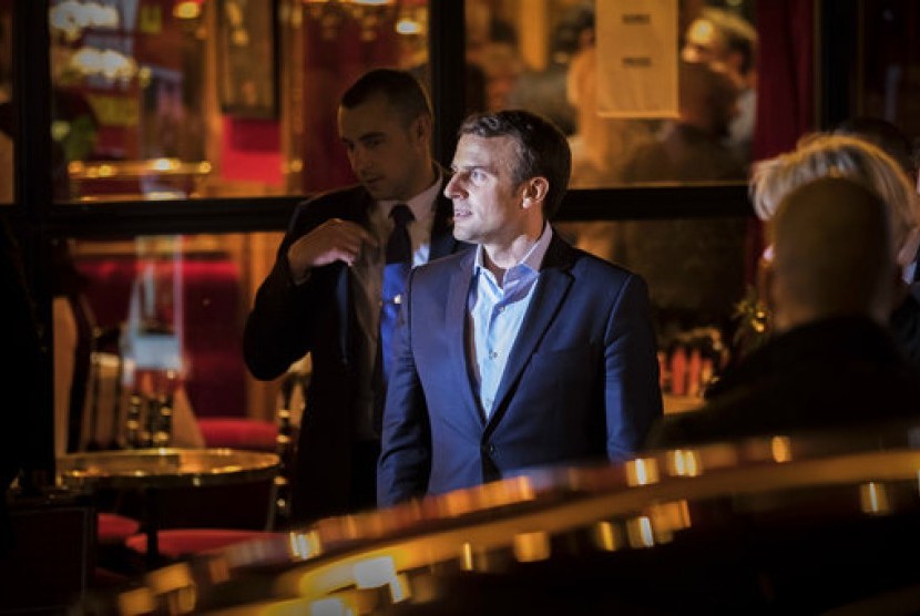 Kandidat presiden Prancis Emmanuel Macron menyapa pendukungnya saat meninggalkan restoran usai kemenangannya di pemilu presiden putaran pertama di Paris, Senin, 24 April 2017.