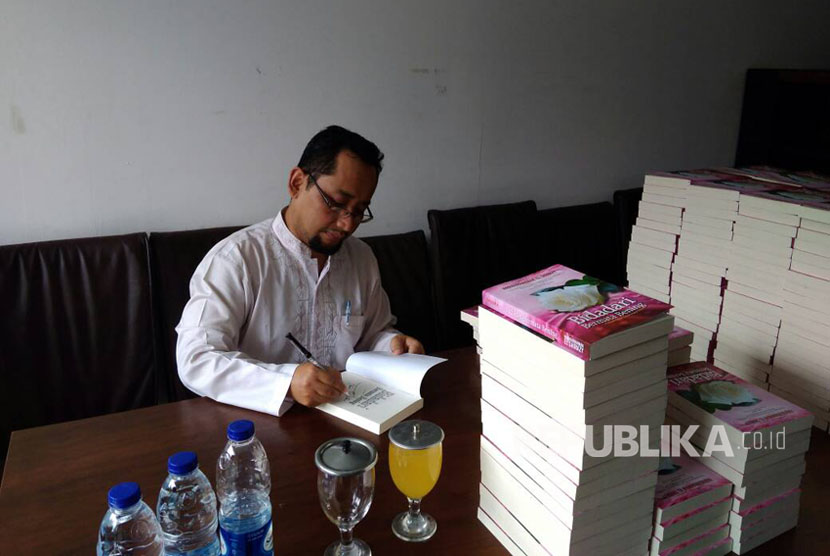 Habiburrahman El Shirazy menandatangani novel Bidadari Bermata Bening untuk pre order.