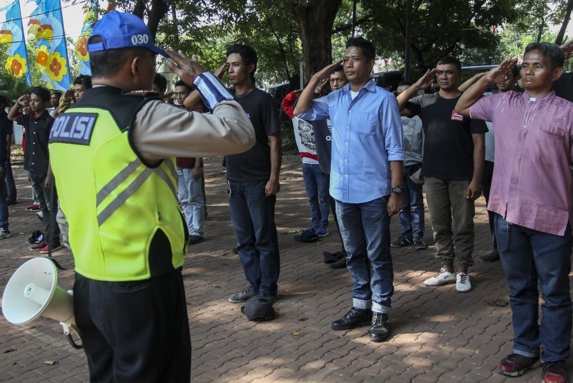 Kanit Pendidikan dan Rekayasa Satlantas Polres Jakpus AKP Antoni Wijaya (kiri) memberikan pelatihan kepada 'Pak Ogah' atau calon Sukarelawan Pengatur Lalu Lintas (supeltas) di Lapangan Banteng, Jakarta, Rabu (23/8). 