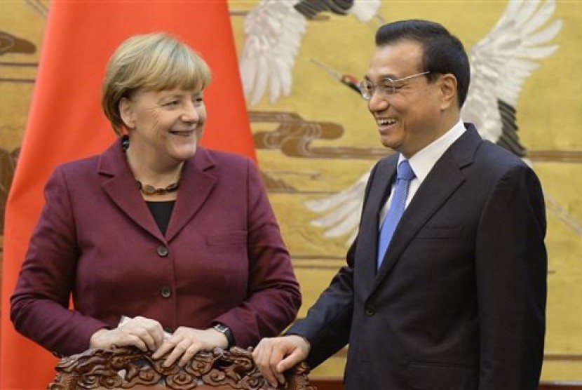 Kanselir Jerman Angela Merkel dan PM Cina Li Keqiang tersenyum usai menandatangani kesepakatan di Great Hall of the People di Beijing, Kamis, 29 Oktober 2015. 