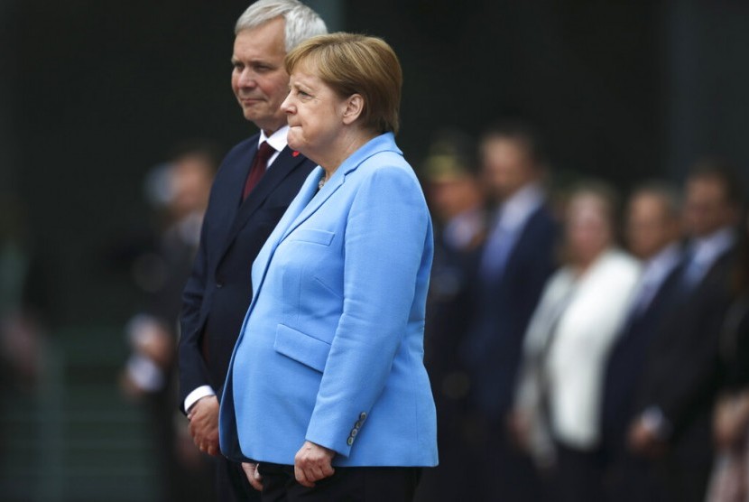 Kanselir Jerman Angela Merkel (kanan) dan Perdana Menteri Finlandia Antti Rinne mendengarkan lagi kebangsaan di Berlin, Jerman, Rabu (10/7). Merkel terlihat berusaha keras mengendalikan tubuhnya yang gemetar untuk ketiga kalinya di depan publik.