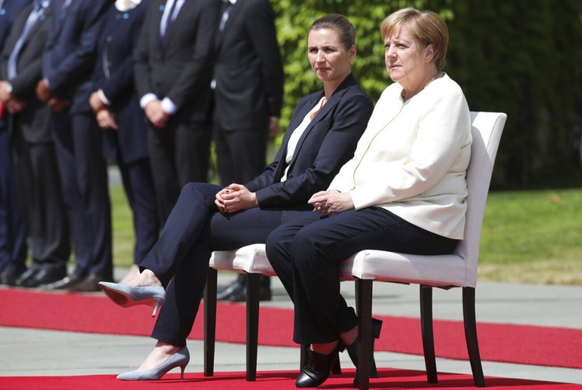 Kanselir Jerman Angela Merkel (kanan) dan tamu negara Perdana Menteri Denmark Mette Frederiksen duduk saat lagu nasional dinyanyikan dalam sebuah acara di Berlin, Jerman, Kamis (11/7).
