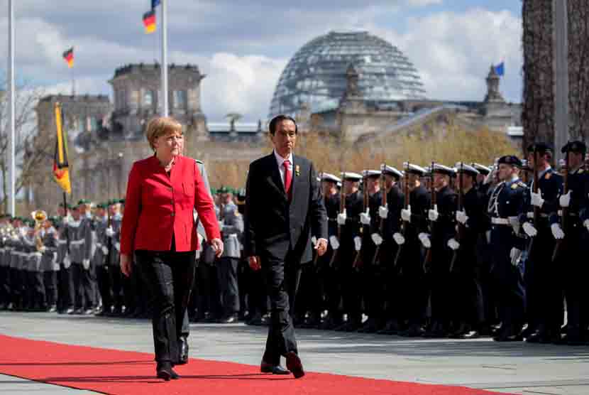   Kanselir Jerman Angela Merkel menyambut Presiden Indonesia Joko Widodo dengan kehormatan militer di luar Kanselir Jerman di Berlin, Jerman, (18/4).