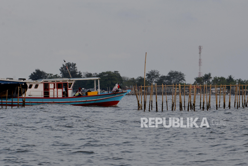 Kapal melintas di dekat pagar laut di kawasan Tanjung Pasir, Kabupaten Tangerang, Banten, Jumat (10/1/2024). Nelayan mengeluhkan sulit mencari tangkapan ikan akibat adanya pagar laut yang membentang di perairan Tangerang, Banten.