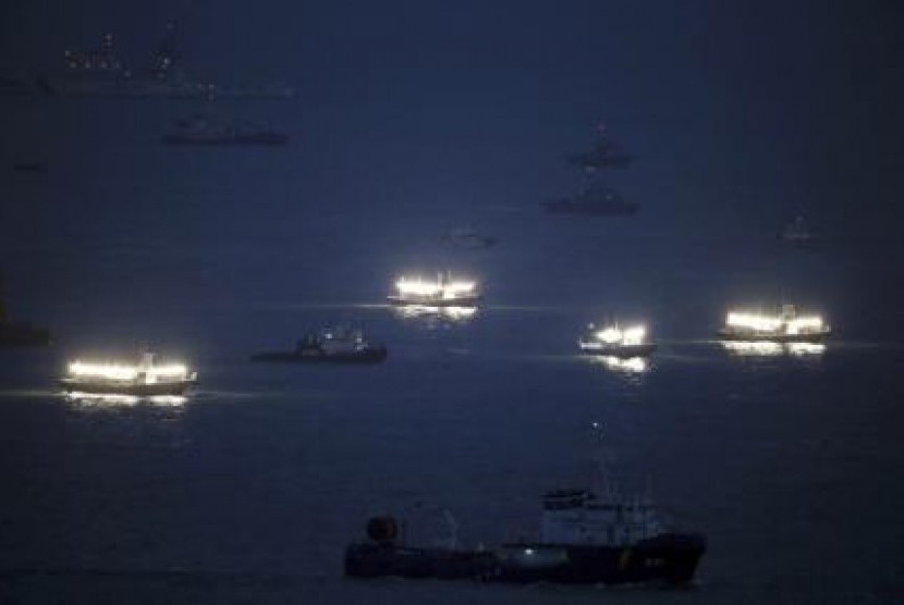 Kapal pencari ikan memancarkan cahaya ke udara dalam upaya pencarian kapal Sewol yang tenggelam di laut Jindo, Korea Selatan.