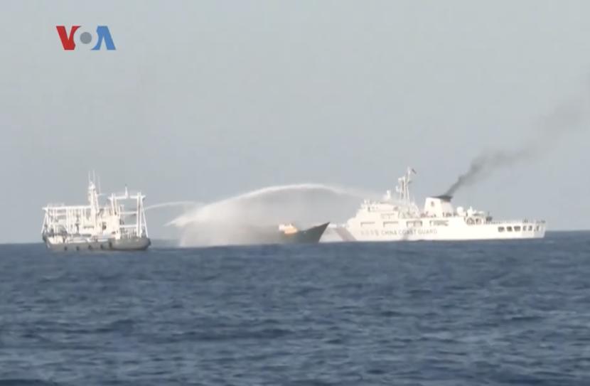 A Chinese coast guard ship deploys water cannon to a Philippine ship in the South China Sea.