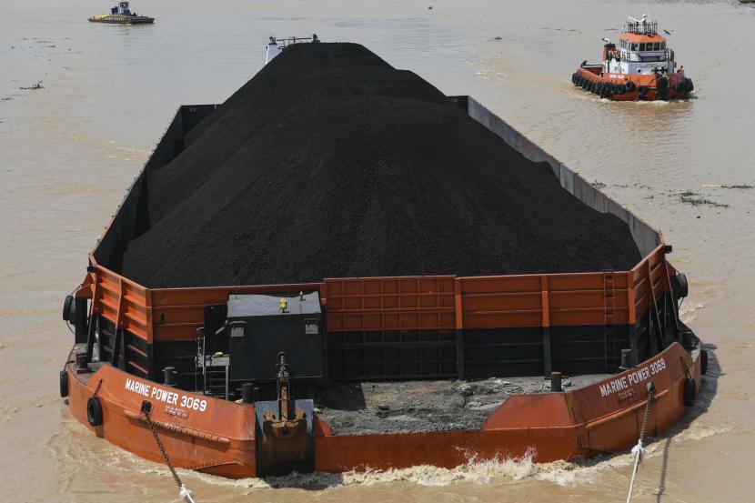 Kapal tongkang pengangkut batu bara melintas di Sungai Musi, Palembang,Sumatera Selatan. Menteri Koordinator Bidang Perekonomian, Airlangga Hartarto memprediksi realisasi DMO tak akan capai target. 