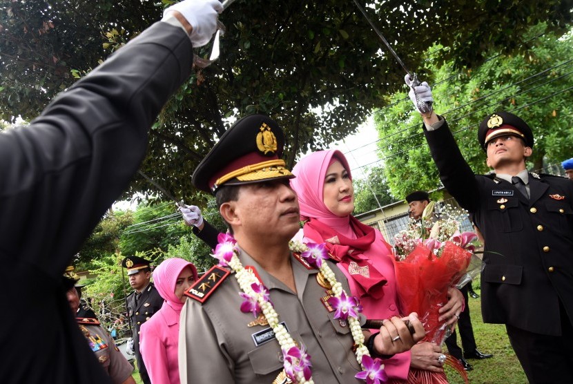 Kapolda Jawa Timur yang baru, Irjen Pol Machfud Arifin (kiri) didampingi istri Ny. Lita Machfud Arifin (kedua kiri) mengikuti prosesi pisah dan sambut di Mapolda Jawa Timur, Surabaya, Kamis (5/1).