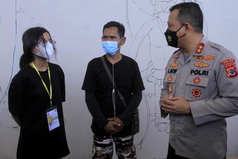 Kapolda NTT Irjen Pol Lotharia Latif (kanan) berbincang dengan dua seniman mural saati lomba menggambar mural di Kota Kupang, NTT, Sabtu (30/10/2021). Sebanyak 22 peserta seniman mural di Kota Kupang dan sekitarnya mengikuti lomba Bhayangkara Festival Mural 2021 itu.
