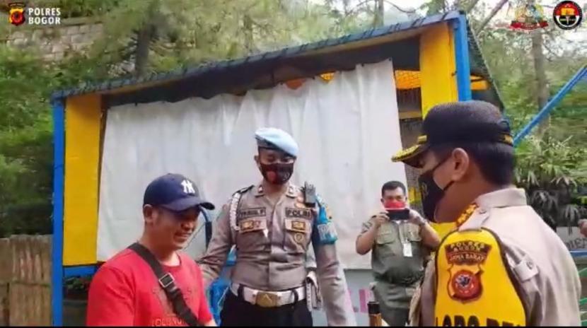 Kapolres Bogor AKBP Ronald Rolandy menegur pengunjur TSI yang tak kenakan masker. Setelah diberi pemahaman pengunjung tersebut diberi masker dan dikenakan.
