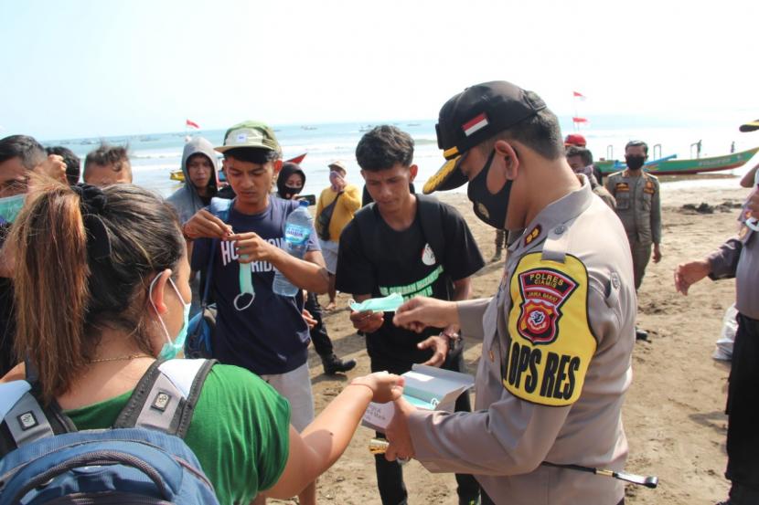 Kapolres Ciamis AKBP Donny Eka Putra membagikan masker kepada wisatawan di Pantai Pangandaran. 