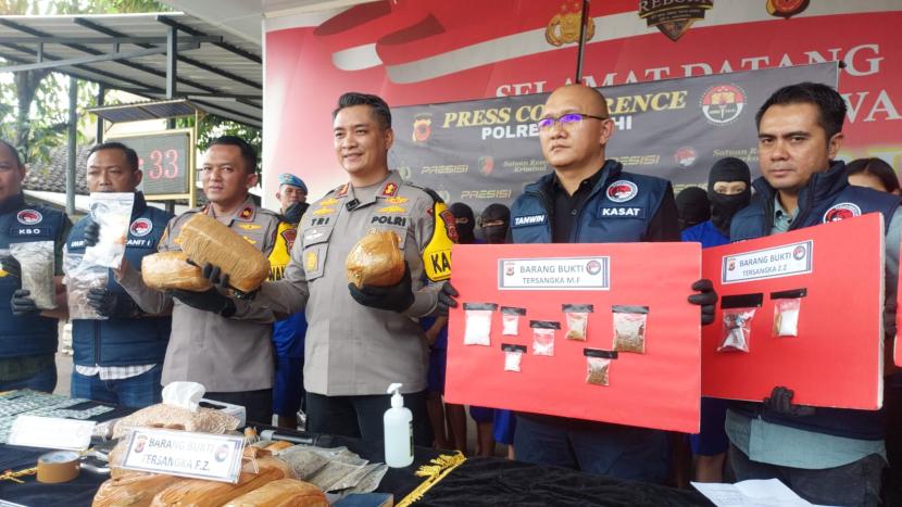 Kapolres Cimahi AKBP Tri Suhartanto (tengah) didampingi Kasat Narkoba Polres Cimahi AKP Tanwin Nopiansah (kanan) melakukan jumpa pers tentang pengungkapan kasus penyalahgunaan narkotika di Mapolres Cimahi, Rabu (24/7/2024). 