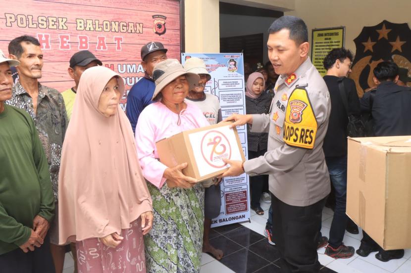 Kapolres Indramayu, AKBP Ari Setyawan Wibowo, membagikan paket sembako kepada warga yang membutuhkan, saat melaksanakan kunjungan kerja di Mako Polsek Balongan, Kabupaten Indramayu, Selasa (27/8/2024). 