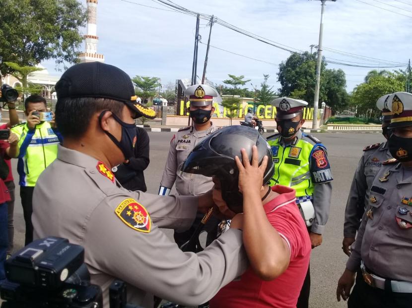 Kapolres Indramayu, AKBP Hafidh S Herlambang memberikan helm gratis kepada pengguna kendaraan yang tidak memakai helm, dalam operasi zebra 2020, di Simpang Lima Indramayu, Sabtu (31/10). Di tengah pandemi, operasi zebra dilakukan secara simpatik. 