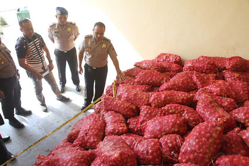 Kapolres Kota Langsa AKBP, Iskandar Za. Sik (kanan) memperlihatkan bawang merah ilegal yang disita di Mapolres Kota Langsa, Langsa, Aceh, Senin (30/5).