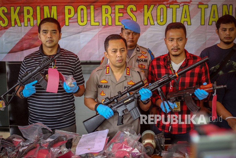 Kapolresta Tangerang Kombes Ade Ary Syam memegang senjata.