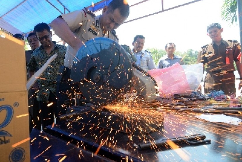 Kapolres Palu AKBP Trisno Rahmadi memotong senpi rakitan hasil sitaan di di kantor Kejaksaan Negeri Palu, Rabu (1/10).