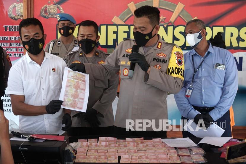 Kapolres Pekalongan AKBP Arief Fajar Satria (kedua kanan) didampingi Kepala Unit Pengelolaan Uang Rupiah Kantor Perwakilan Bank Indonesia Tegal Muhammad Ramadi (kanan) menunjukkan uang palsu saat gelar kasus di Polres Pekalongan, Jawa Tengah, Rabu (2/3/2022). Polres Pekalongan berhasil mengamankan dua tersangka pembuat dan pengedar uang palsu dengan masing-masing barang bukti uang palsu pecahan Rp50 ribu dan Rp100 ribu senilai total Rp78.250.000 dan uang palsu pecahan lima ribu, 10 ribu, 50 ribu, dan 100 ribu senilai total Rp2,5 juta dengan kedua tersangka diancam hukuman paling lama 15 tahun penjara dan denda paling banyak Rp50 miliar. 