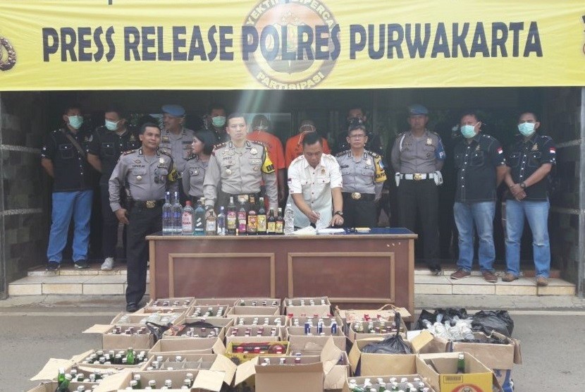 Kapolres Purwakarta AKBP Dedy Tabrani di dampingi Kasat Narkoba AKP Heri Nurcahyo, memerlihatkan ribuan botol miras hasil razia selama operasi lilin, Senin (25/12). 