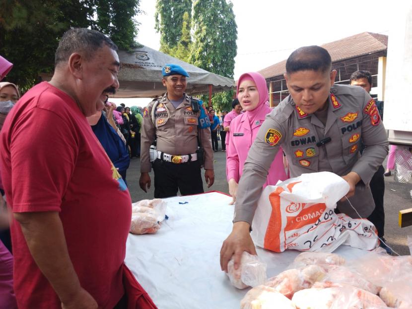 Kapolres Purwakarta AKBP Edwar Zulkarnain melayani konsumen saat operasi pasar daging ayam di Mapolres. 
